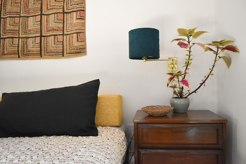 a nightstand with gold articulated lamp with teal lampshade in a guest and craft room designed by Brand*Eye Home