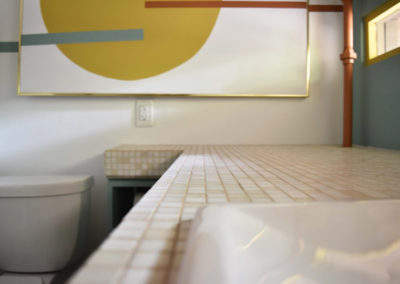 detail of the cream checkered tile countertop in a bathroom designed by Brand*Eye Home
