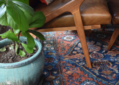 detail shot of a decorative rug under a midcentury modern chair and potted plant, in a reading nook designed by Brand*Eye Home