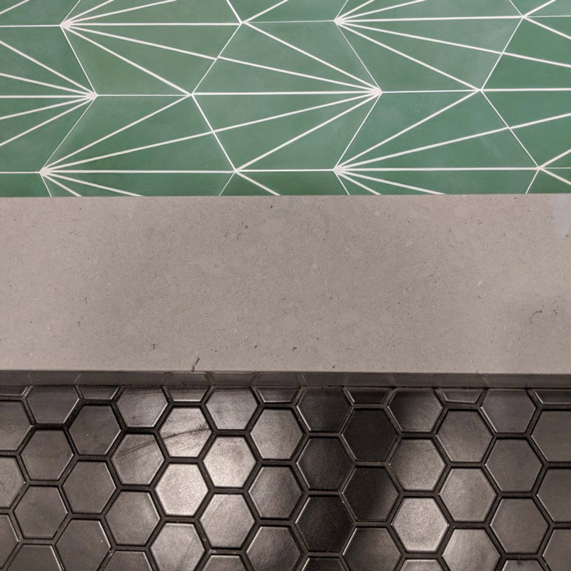 texture of a green art deco hexagon tile, concrete, and black honeycomb rubber