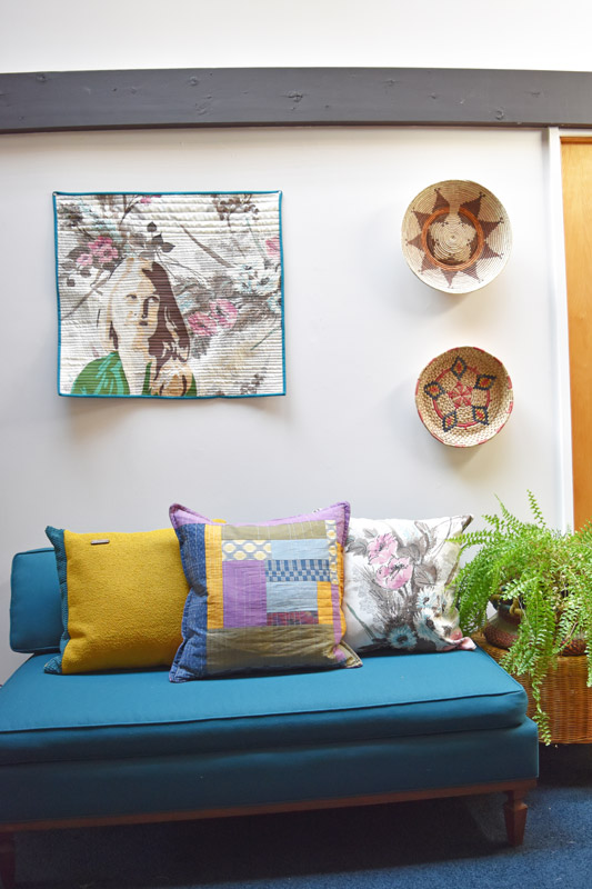 a handmade quilt showing a portrait of Brandi hung on the wall of a room designed by Brand*Eye Home