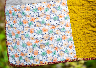 a mustard, white, and floral patterned custom handmade quilt from Brand*Eye Home