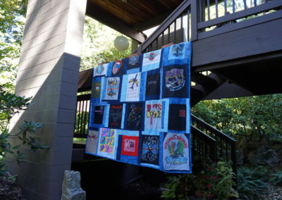 a large quilt featuring band poster patterns, handmade by Brand*Eye Home
