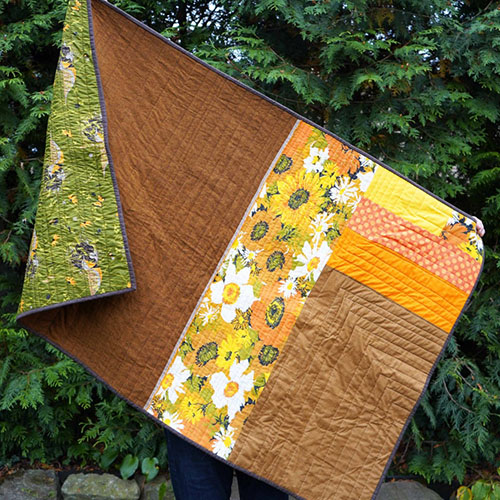 a yellow, brown, green, and floral patterned custom handmade quilt from Brand*Eye Home